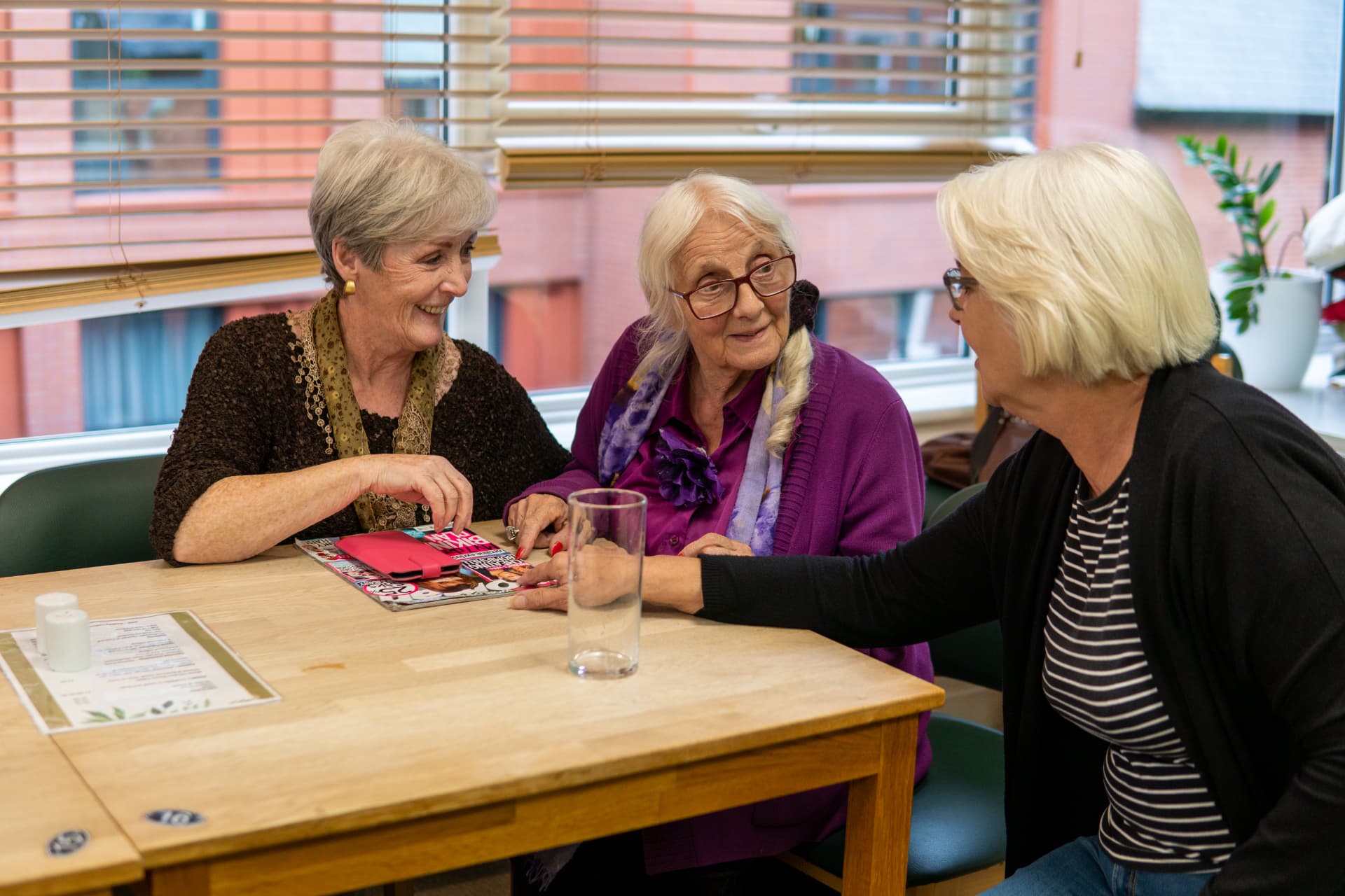 Older friends sharing conversation around a table