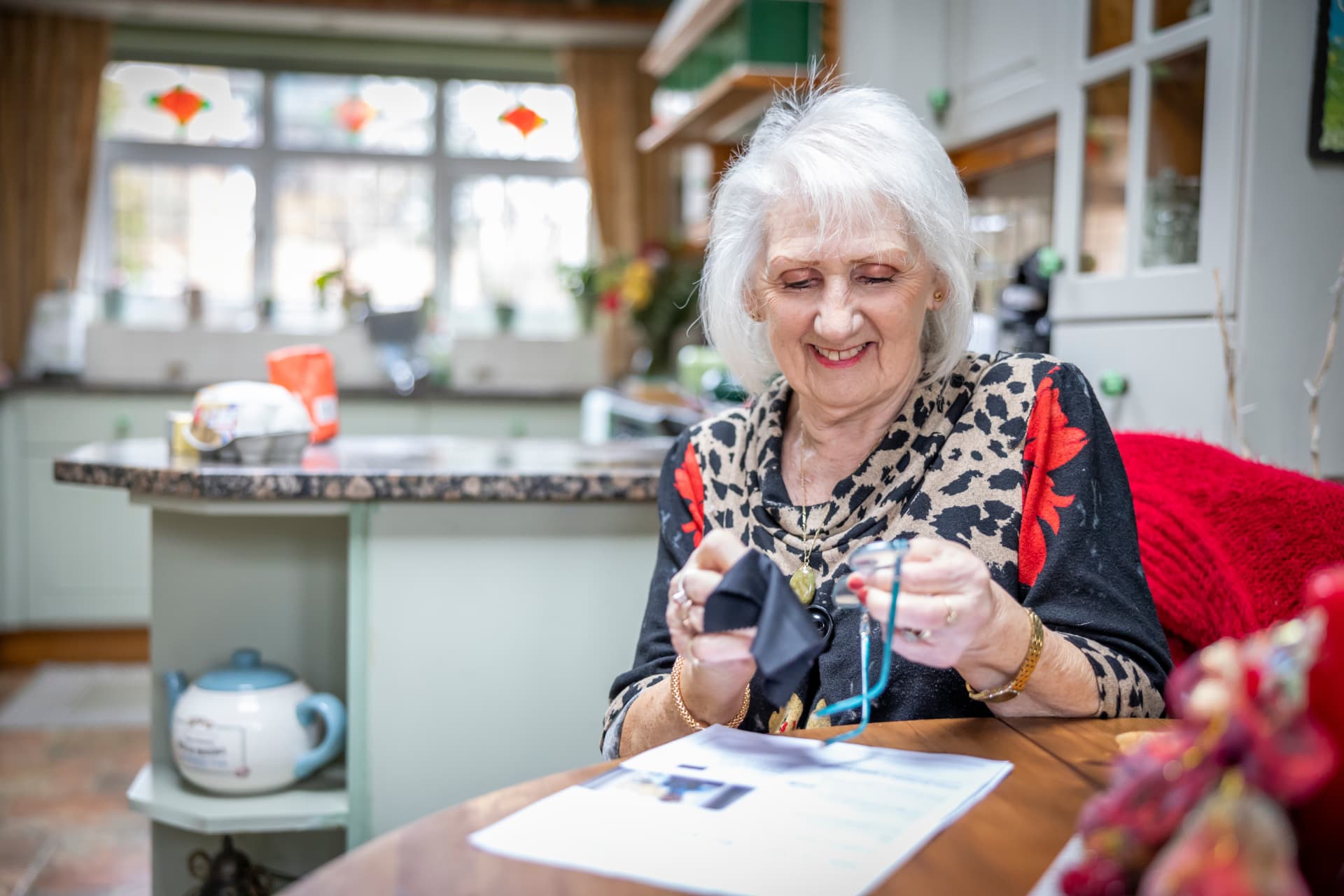 A smiling older woman enjoying an activity at home